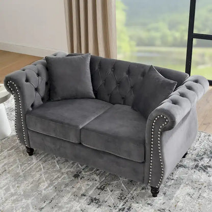 Canapé Chesterfield deux places en velours, accoudoirs arrondis, garniture cloutée