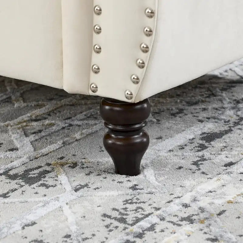 Canapé Chesterfield deux places en velours, accoudoirs arrondis, garniture cloutée