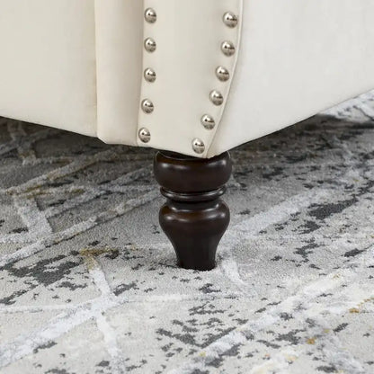 Canapé Chesterfield deux places en velours, accoudoirs arrondis, garniture cloutée